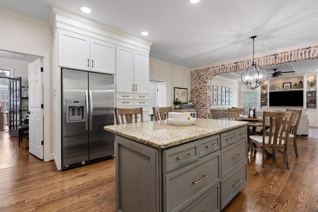 kitchen featuring built in fridge, dark hardwood / wood-style floors, white cabinetry, and hanging light fixtures