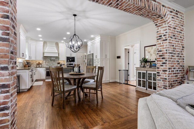 dining room with hardwood / wood-style flooring, a notable chandelier, and ornamental molding