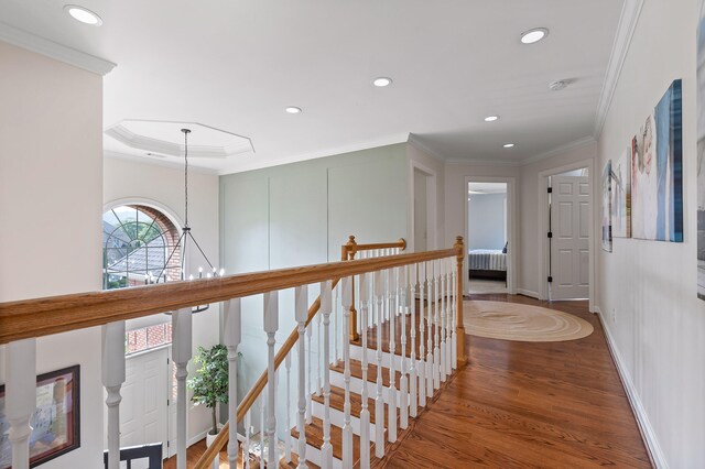 hallway with hardwood / wood-style flooring, a notable chandelier, and ornamental molding