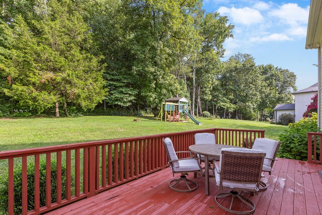 deck with a playground and a lawn