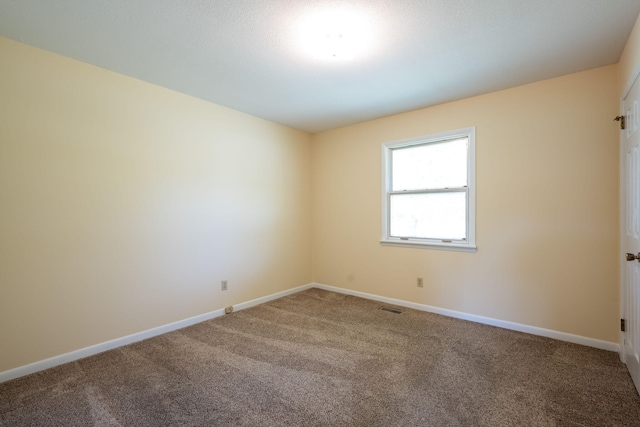 carpeted empty room with visible vents and baseboards