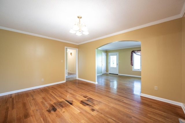 empty room with a notable chandelier, arched walkways, baseboards, light wood-type flooring, and ornamental molding