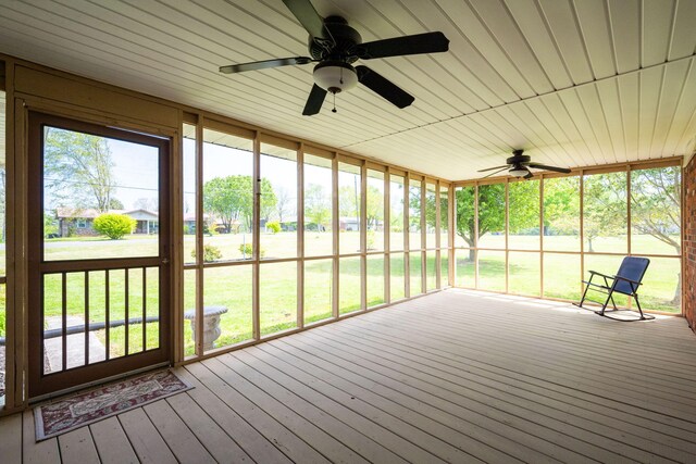 unfurnished sunroom featuring a ceiling fan