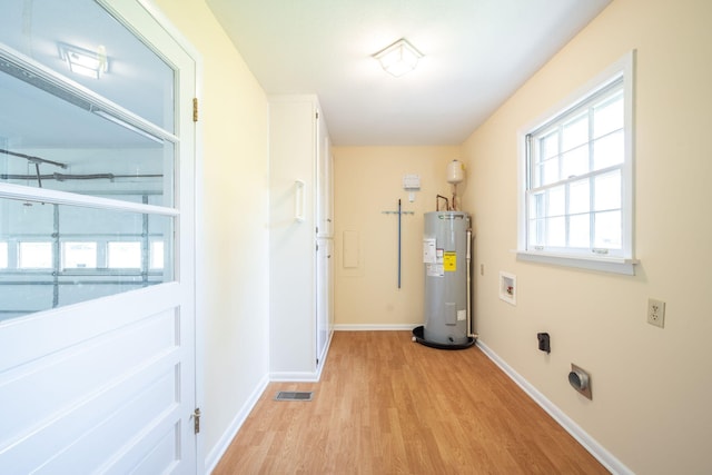 utilities with water heater and visible vents