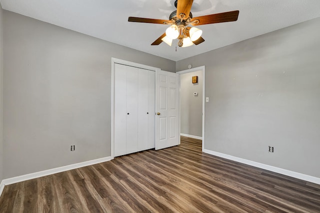 unfurnished bedroom with a closet, dark hardwood / wood-style floors, and ceiling fan