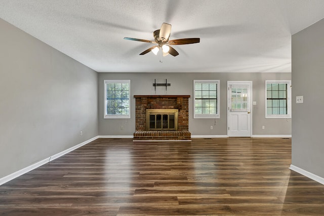 unfurnished living room featuring a fireplace, dark hardwood / wood-style flooring, and a wealth of natural light