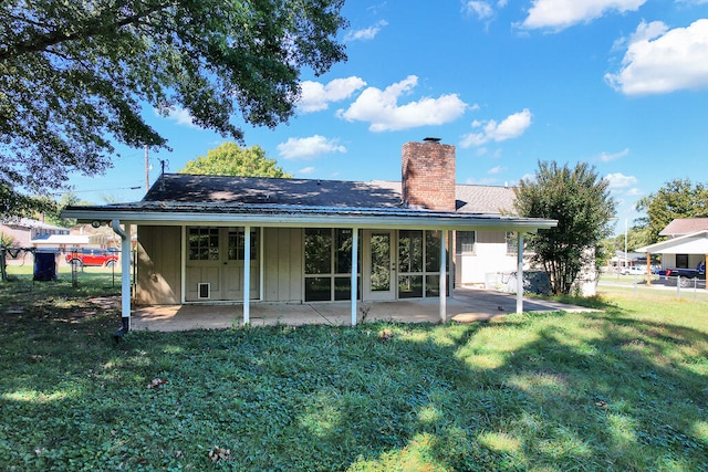 back of house with a lawn and a patio area