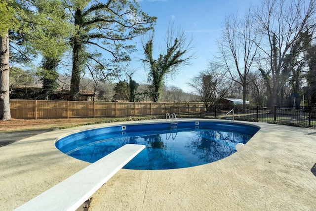 view of pool with a diving board and a patio area