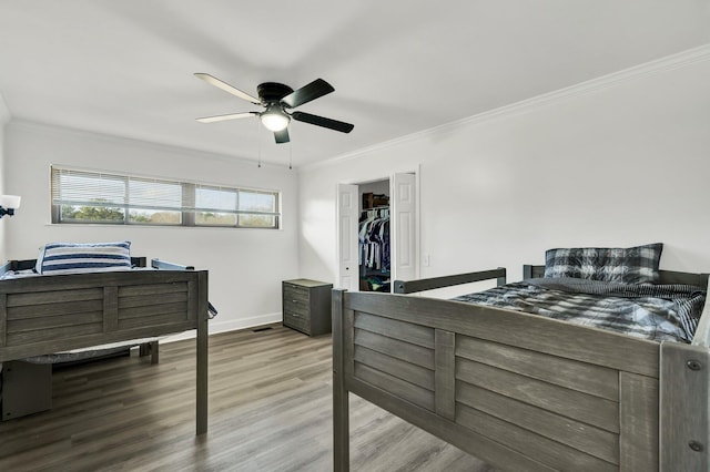 bedroom with hardwood / wood-style flooring, ceiling fan, and ornamental molding