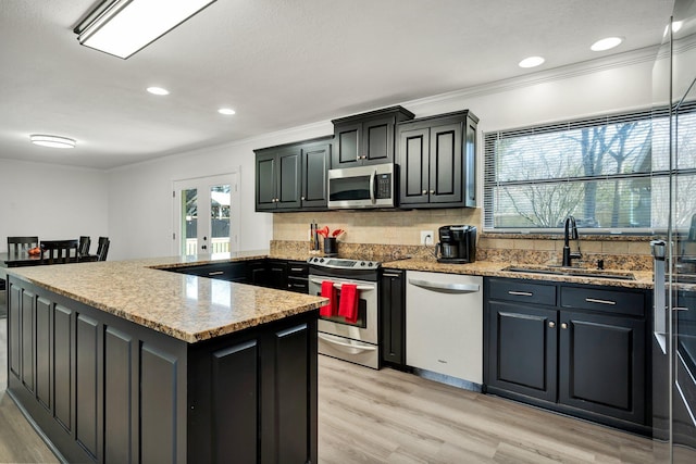 kitchen featuring french doors, sink, light stone counters, light hardwood / wood-style flooring, and appliances with stainless steel finishes