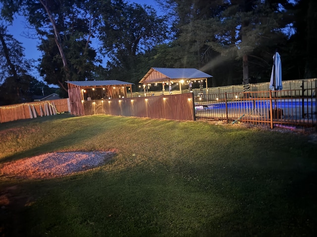 yard at night featuring a gazebo and a fenced in pool