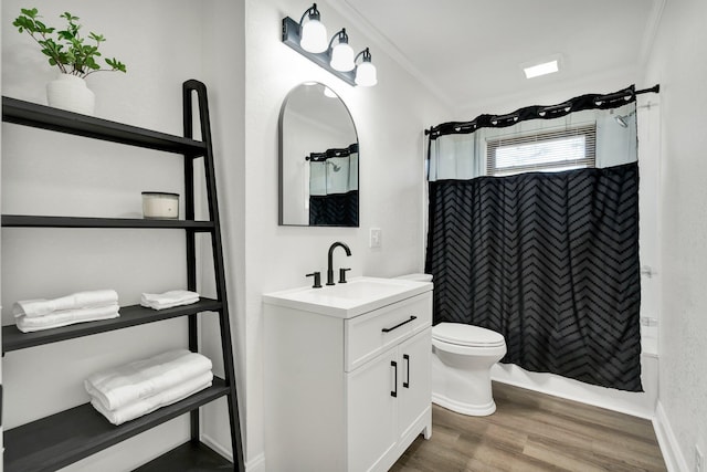 bathroom featuring vanity, crown molding, wood-type flooring, and toilet