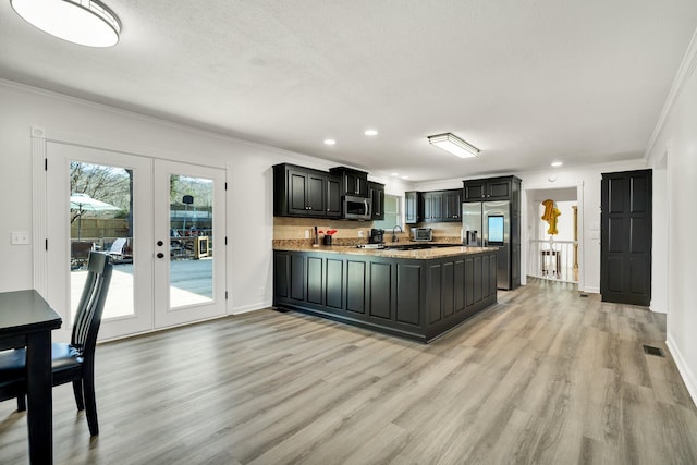 kitchen with stainless steel appliances, ornamental molding, light hardwood / wood-style flooring, and french doors