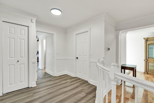 corridor with hardwood / wood-style flooring and crown molding