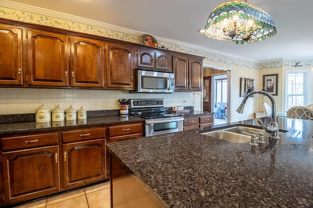 kitchen with light tile patterned floors, a sink, decorative backsplash, ornamental molding, and stainless steel appliances