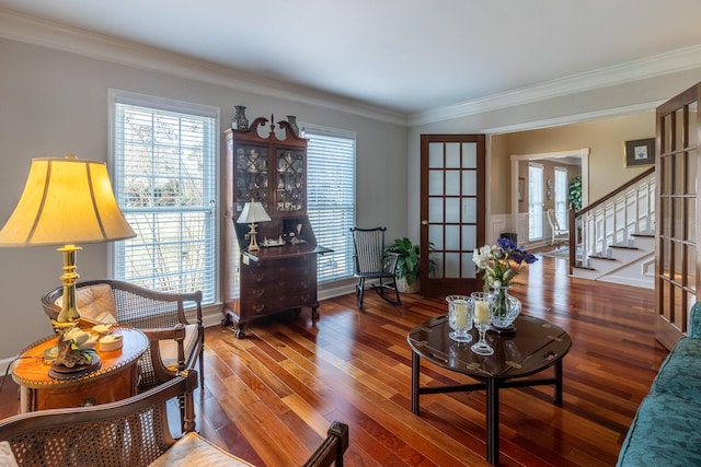 living area with french doors, wood finished floors, stairs, and ornamental molding
