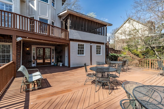 deck with outdoor dining area, french doors, and a sunroom