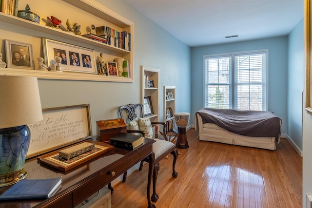 living area with hardwood / wood-style floors, baseboards, and visible vents