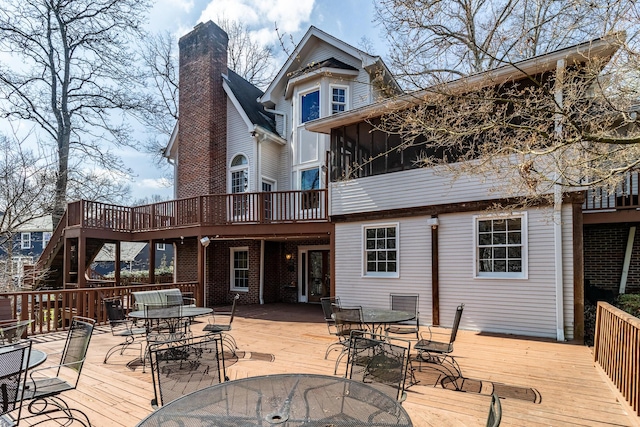 deck with outdoor dining space and a sunroom