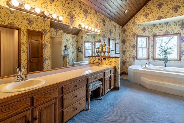 bathroom with vaulted ceiling, wallpapered walls, a garden tub, and a sink