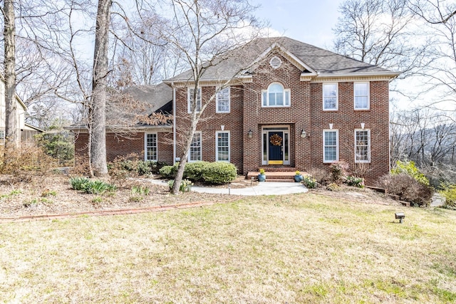 view of front of home with brick siding, roof with shingles, and a front lawn