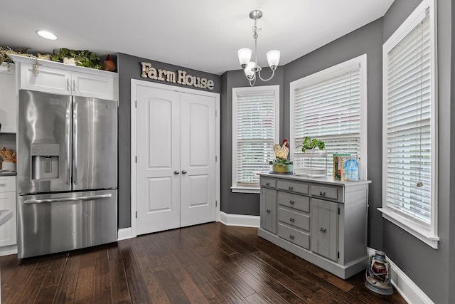 kitchen featuring stainless steel fridge, pendant lighting, white cabinetry, and dark wood-type flooring