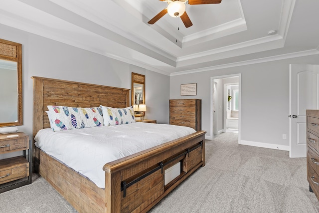 bedroom with light carpet, connected bathroom, a raised ceiling, and ceiling fan