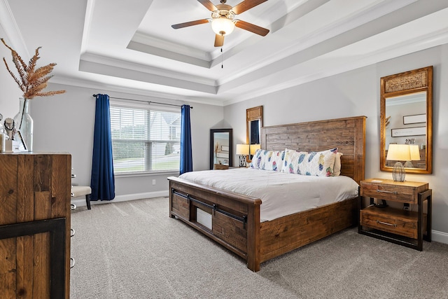 carpeted bedroom featuring a tray ceiling, ceiling fan, and ornamental molding