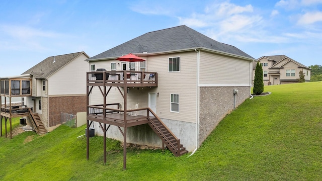 rear view of property with a sunroom, a yard, and a wooden deck