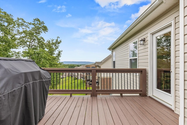 wooden terrace featuring area for grilling and a lawn