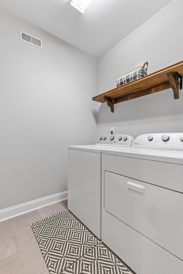 washroom featuring washer and clothes dryer and light tile patterned floors