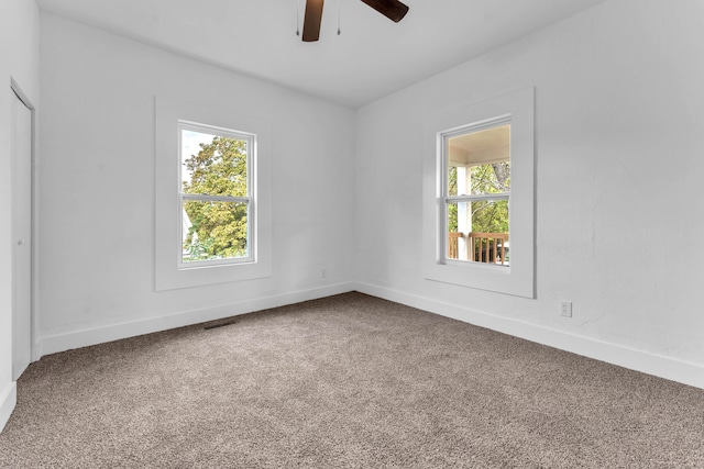 carpeted spare room featuring ceiling fan