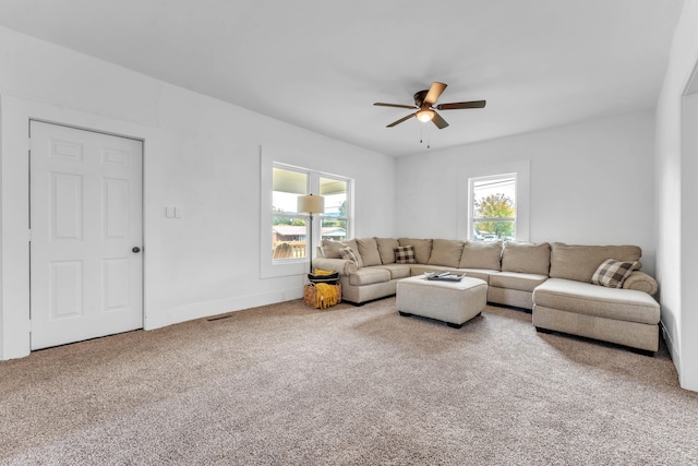 carpeted living room featuring ceiling fan and a wealth of natural light