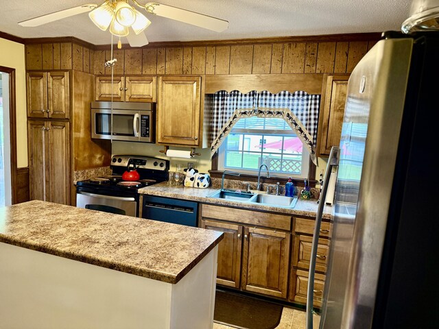 2510 Burning Tree Dr NW, Cleveland, TN 37312 - kitchen with crown molding, a sink, appliances with stainless steel finishes, wood walls, and brown cabinetry