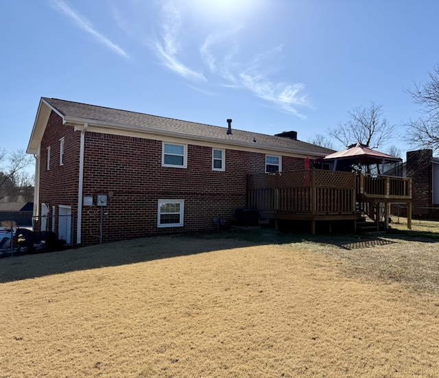 rear view of house with a gazebo, a yard, and a deck