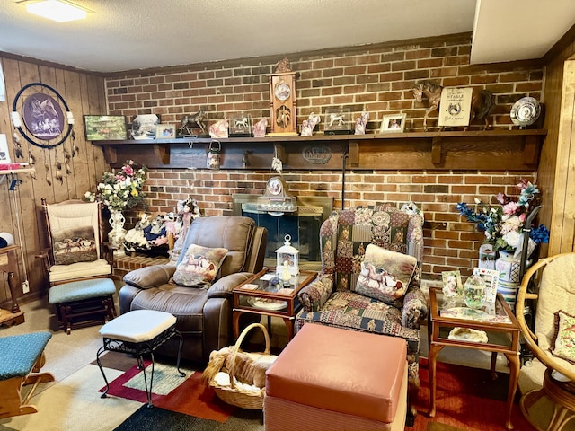 living room with brick wall, carpet, a textured ceiling, and wood walls