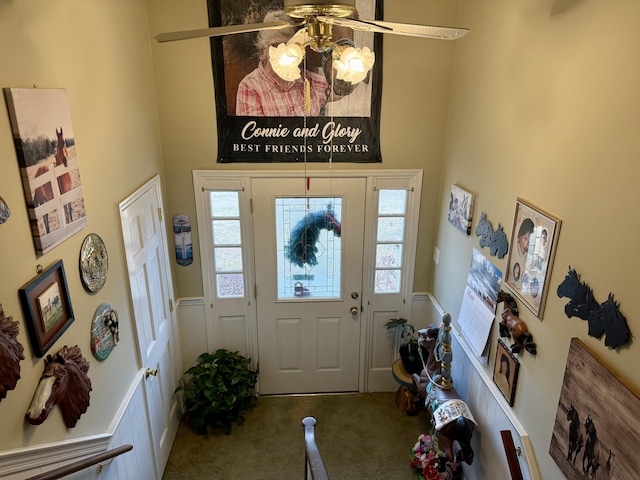 carpeted foyer entrance featuring ceiling fan