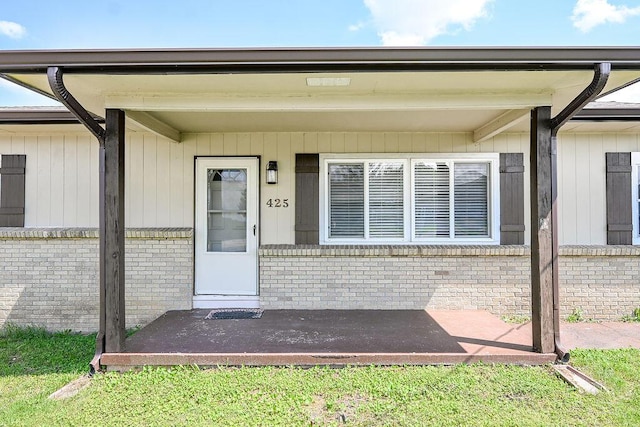 view of exterior entry with brick siding