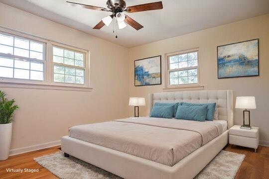 bedroom featuring wood-type flooring, multiple windows, and ceiling fan