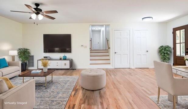 living room with light hardwood / wood-style floors and ceiling fan