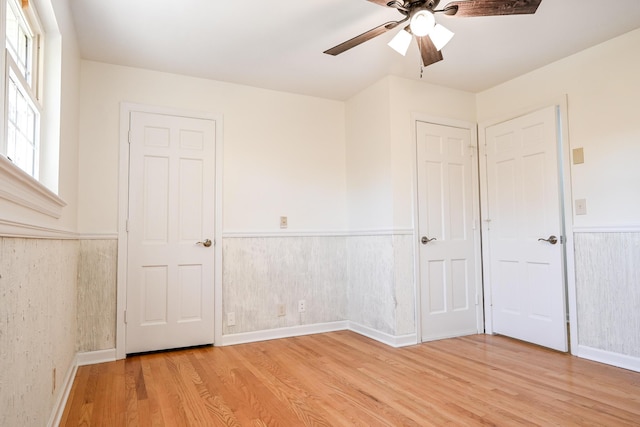 unfurnished bedroom with ceiling fan and light hardwood / wood-style flooring