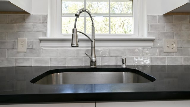 room details with sink, white cabinets, and decorative backsplash