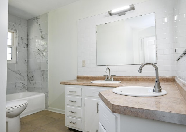 full bathroom with tile patterned flooring, toilet, vanity, tiled shower / bath, and backsplash