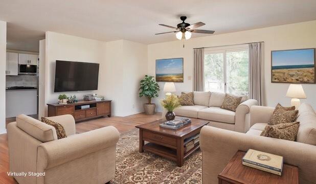 living room featuring ceiling fan and hardwood / wood-style flooring