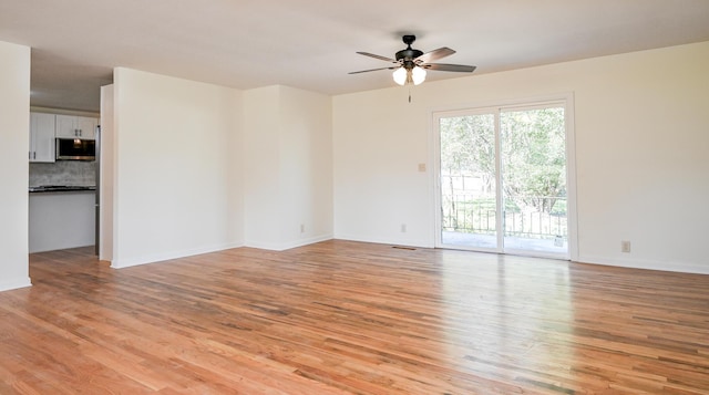 spare room featuring ceiling fan and light hardwood / wood-style flooring