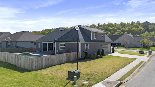 rear view of property with central AC, driveway, a shingled roof, fence private yard, and a yard