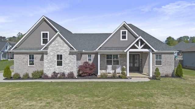 craftsman house featuring french doors, roof with shingles, stone siding, and a front yard