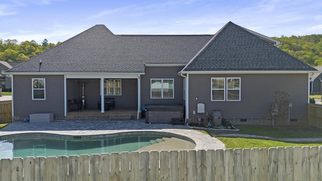 rear view of property featuring a fenced backyard, a hot tub, a patio area, and a fenced in pool