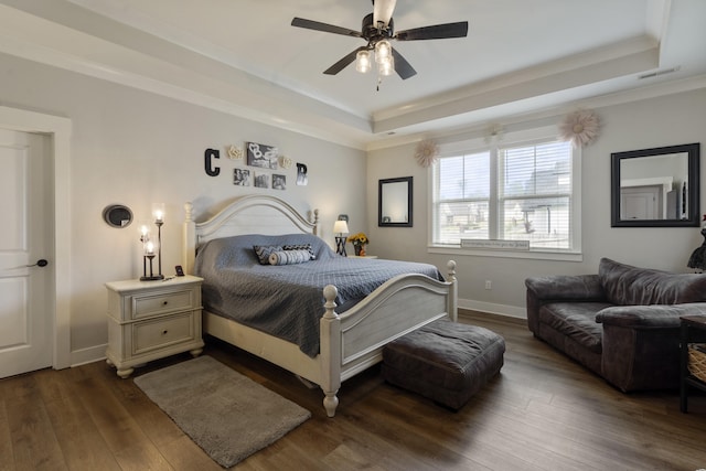 bedroom featuring ornamental molding, hardwood / wood-style flooring, baseboards, and a raised ceiling