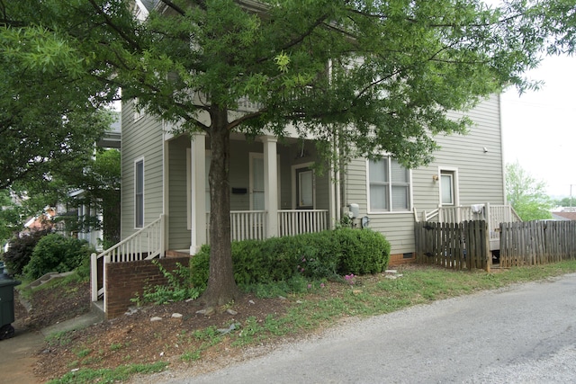 view of front of house featuring fence, a porch, and crawl space